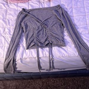 Grey plunged neck cropped long sleeve top, ties up the front, stretchy fabric